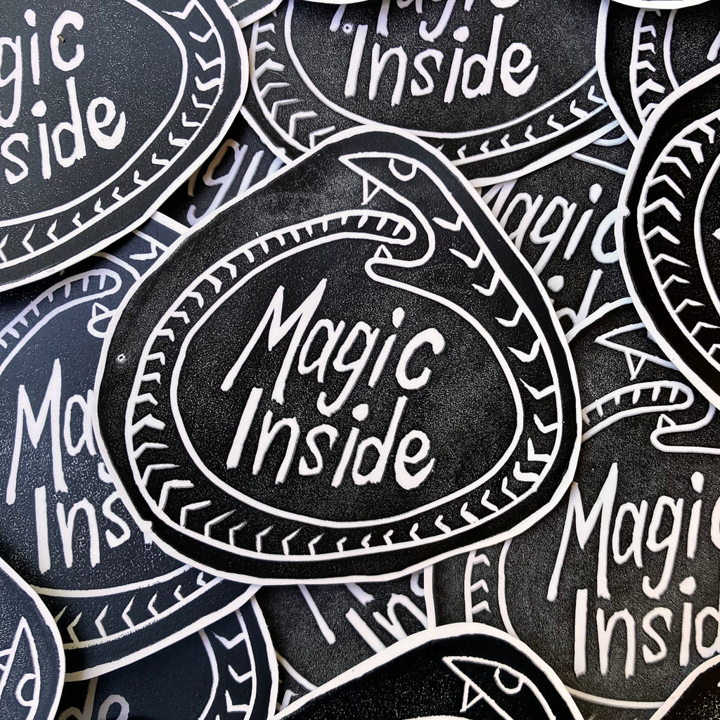 Stickers with 'Magic Inside' text on a black background
